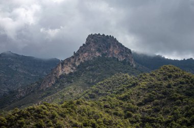 İspanya 'nın Frigiliana kentindeki eski bir sulama hendeği boyunca bir yürüyüş yolundan çevresindeki dağların ve resimli köyün manzarası..