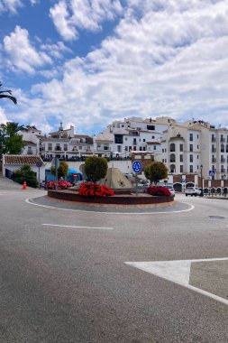 FRIGILIANA, SPAIN - 10 Mayıs 2025: Frigiliana, İspanya 'da beyazlatılmış evler ve renkli çiçeklerle çevrili büyüleyici dar sokaklarda huzurlu bir yürüyüş