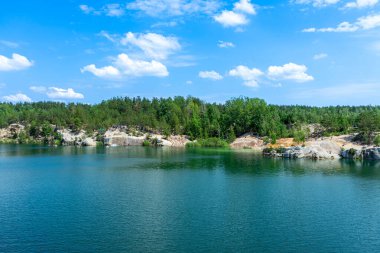 KOROSTYSHIV, UKRAINE - 21 Haziran 2020: Terk edilmiş Korostyshiv taş ocağı, derin mavi suları ve engebeli uçurumlarıyla dinlenme, balık tutma ve yüzme için manzaralı bir yer haline geldi..