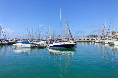 BENALMADENA, SPAIN - 24 Mayıs 2025 İspanya 'nın canlı limanı Benalmadena' da, kıyı cazibesi ve deniz zarafeti ile çevrili demirlemiş yatlar arasında rahatlatıcı bir yürüyüş yapmak.