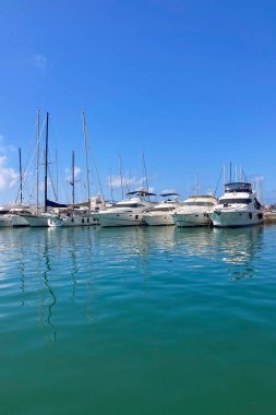 BENALMADENA, SPAIN - 24 Mayıs 2025 İspanya 'nın canlı limanı Benalmadena' da, kıyı cazibesi ve deniz zarafeti ile çevrili demirlemiş yatlar arasında rahatlatıcı bir yürüyüş yapmak.