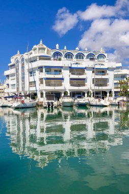 BENALMADENA, SPAIN - 24 Mayıs 2025 İspanya 'nın canlı limanı Benalmadena' da, kıyı cazibesi ve deniz zarafeti ile çevrili demirlemiş yatlar arasında rahatlatıcı bir yürüyüş yapmak.