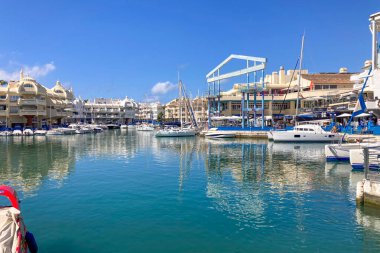 BENALMADENA, SPAIN - 24 Mayıs 2025 İspanya 'nın canlı limanı Benalmadena' da, kıyı cazibesi ve deniz zarafeti ile çevrili demirlemiş yatlar arasında rahatlatıcı bir yürüyüş yapmak.