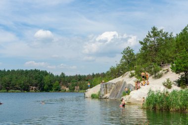 KOROSTYSHIV, UKRAINE - 21 Haziran 2020: Terk edilmiş Korostyshiv taş ocağı, derin mavi suları ve engebeli uçurumlarıyla dinlenme, balık tutma ve yüzme için manzaralı bir yer haline geldi..