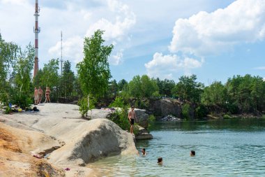 KOROSTYSHIV, UKRAINE - 21 Haziran 2020: Terk edilmiş Korostyshiv taş ocağı, derin mavi suları ve engebeli uçurumlarıyla dinlenme, balık tutma ve yüzme için manzaralı bir yer haline geldi..