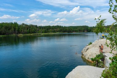 KOROSTYSHIV, UKRAINE - 21 Haziran 2020: Terk edilmiş Korostyshiv taş ocağı, derin mavi suları ve engebeli uçurumlarıyla dinlenme, balık tutma ve yüzme için manzaralı bir yer haline geldi..