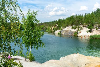 KOROSTYSHIV, UKRAINE - 21 Haziran 2020: Terk edilmiş Korostyshiv taş ocağı, derin mavi suları ve engebeli uçurumlarıyla dinlenme, balık tutma ve yüzme için manzaralı bir yer haline geldi..