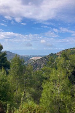 İspanya 'nın Frigiliana kentindeki eski bir sulama hendeği boyunca bir yürüyüş yolundan çevresindeki dağların ve resimli köyün manzarası..