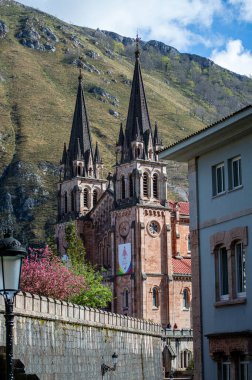 COVADONGA, İspanya - 6 Nisan 2025: Asturias 'taki Covadonga kutsal mağarası, bazilikası ve çarpıcı doğal çevresiyle bilinen tarihi bir dağ köyüdür..