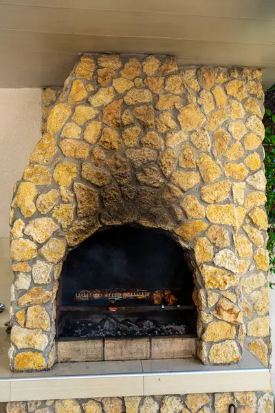 Doğal taştan yapılmış, ızgara yapmak ve toplamak için mükemmel, kırsal bir barbekü şöminesi..