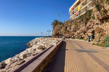 TORREMOLINOS, SPAIN - 24 Mayıs 2025: İspanya 'nın Torremolinos kıyı şeridi boyunca huzurlu bir yürüyüş, manzaralı ve ferahlatıcı bir deniz meltemi.