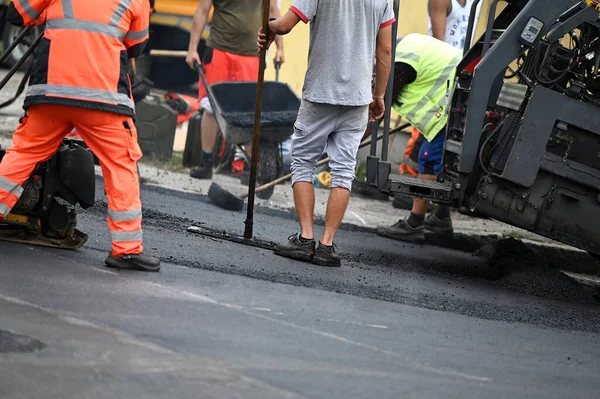 stock image Feet of construction workers paving a road