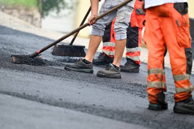 Yol döşeyen inşaat işçilerinin ayakları