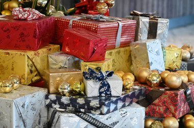 Masadaki çeşitli Noel paketleri ve altın toplar