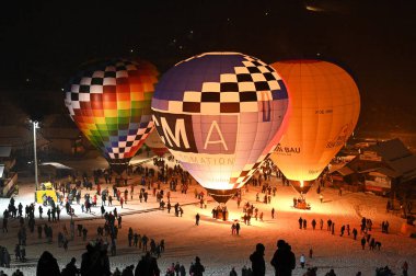 At the night of the balloons, the balloonists fire their balloons on the ground and create a colorful spectacle