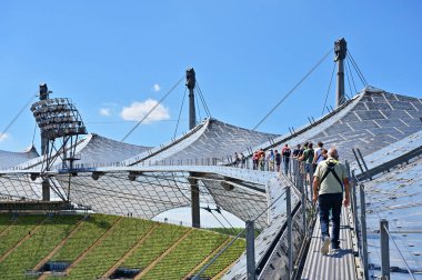 Münih 'teki Olimpiyat Stadyumu' nun çarpıcı çadır çatısı ile, rehberli turlar kapsamında çadır çatısı üzerinde yürüyebilirsiniz.