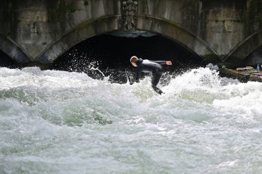 Eisbachwelle, İngiliz Bahçesi 'nin Eisbach' ında tüm yıl boyunca sörf yapmak için ideal yapay bir dalgadır..
