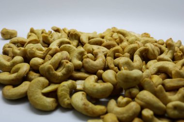 Beyaz arka planda izole edilmiş kavrulmuş kaju fıstığı..