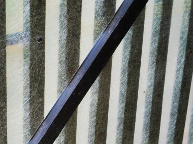 Çapraz destek kirişini barındıran yıpranmış metal yüzeyin detaylı görüntüsü. Doku ve desenler endüstriyel ve kırsal elementleri gösteriyor, maddenin dayanıklılığını ve dayanıklılığını vurguluyor..