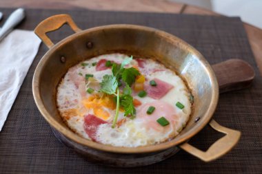 Küçük bir tavada yumurta, kıyma ve ahşap tepside servis edilen sosisler, Kai Kata adlı Tayland Kahvaltısı 'nın yemekleri.
