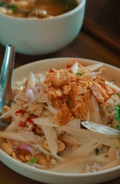 Beyaz tabak üst görünümlü baharatlı Papaya salatası.