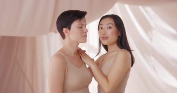 两个漂亮可爱的女人穿着米黄色的水槽和赤裸的浅妆的肖像 迷人迷人迷人的女性模特 完美的皮肤站立 在工作室里摆姿势 自然妆容概念 — 图库视频影像
