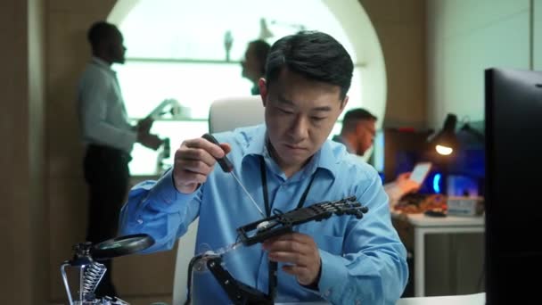 用工具塑造和设置机器人手部假肢的成功亚洲人的肖像 在现代公司办公室工作的英俊聪明的男性工程师 技术概念 — 图库视频影像