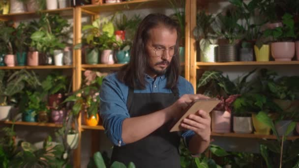Portrait Concentrated Beautiful Long Haired Man Working Florist Using Tablet — Stock Video