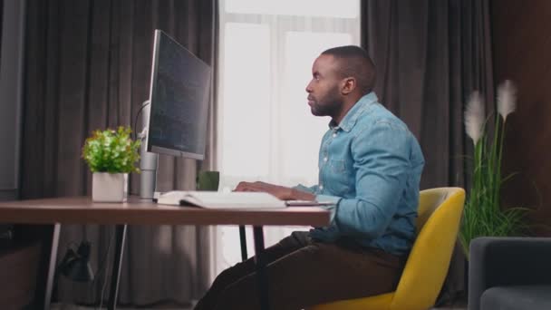 Zooma Den Afroamerikanska Mannen Som Sitter Framför Datorskärmen Och Skriver — Stockvideo