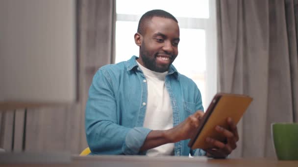 Αφροαμερικανός Χαρούμενος Χαρούμενος Τύπος Που Εργάζεται Στον Υπολογιστή Tablet Απευθείας — Αρχείο Βίντεο