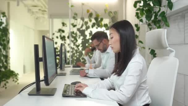 아름다운 아시아 컴퓨터 타이핑으로 사무실에서 동료들 일하는 모습입니다 온라인으로 일하는 — 비디오