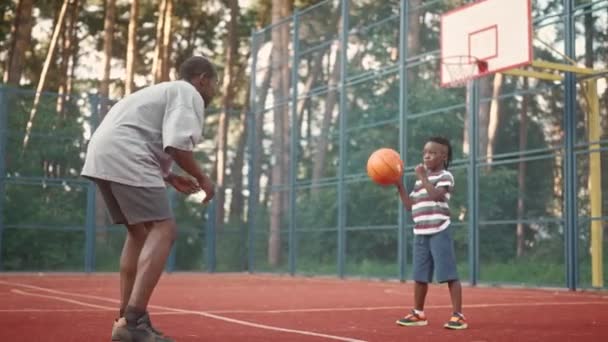 Афроамериканець Маленький Хлопчик Кидають Один Одного Баскетбол Вулиці Місті Батько — стокове відео