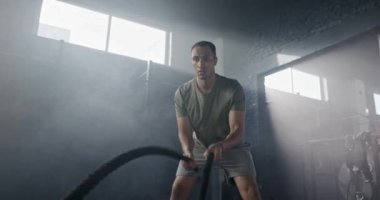 Spor kıyafetleri içinde yakışıklı kaslı bir adamın elini tutup dumanlı karanlık spor salonunda tek başına antrenman yapması. Çekici erkek spor yapmaya ya da ısınmaya konsantre oluyor. Fitness konsepti.