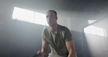 Smoky Dark Spor Merkezi 'nde ipleri kullanarak Afro-Amerikan atletik adamı uzaklaştırmak. Genç ve güçlü bir adam, kaslarını geliştiriyor, çalışıyor ya da vücudunu esnetiyor. Vücut geliştirici, sporcu konsepti.