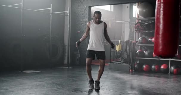 英俊的非洲裔美国人在黑暗的体育馆里学习跳绳 有魅力的男性穿着绷带运动服 专注于运动 致力于健康 体育概念 — 图库视频影像