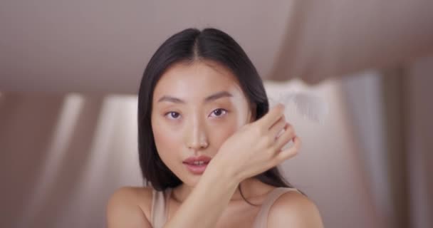 Nahaufnahme Einer Asiatin Die Das Gesicht Mit Federn Berührt Und — Stockvideo