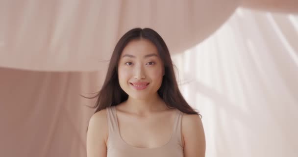 年轻的亚洲女人的画像 笔直地凝视着 怒视着 眨着眼睛 愉快地微笑着 风吹的头发 吹的空气 积极的女性 快乐的感觉 青少年皮肤护理概念 — 图库视频影像