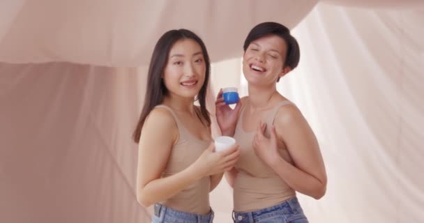 Porträt Kaukasischer Und Asiatischer Frauen Die Mit Kosmetischer Creme Oder — Stockvideo