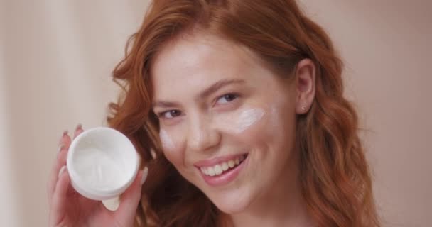 Retrato Mujer Caucásica Con Pelo Rojo Rizado Aplicando Crema Facial — Vídeos de Stock
