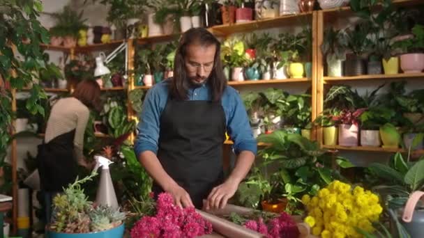Schöne Männliche Floristin Mit Schwarzer Schürze Die Blumensträuße Mit Roten — Stockvideo