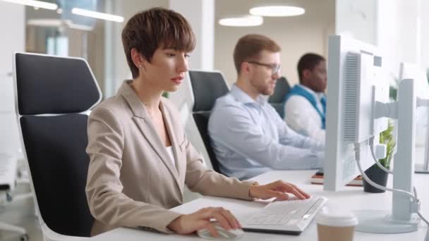 漂亮的高加索女人坐在显示器前 在键盘上打字 除了她可见的努力工作的男人使用计算机 在控制中心一起工作 业务概念 — 图库视频影像