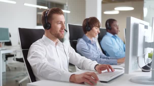 Kelompok Operator Multietnis Dengan Headset Duduk Meja Fokus Menjawab Panggilan — Stok Video