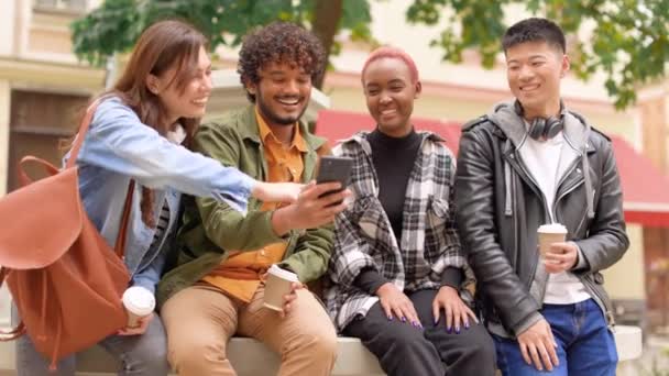 Vidám Vegyes Fajú Változatos Fiatalok Ülnek Szabadban Nevetnek Okostelefon Képernyőjén — Stock videók