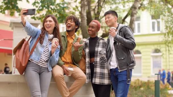 快乐多种族的年轻貌美的人在城外的喷泉前摆出智能手机相机的姿势 多种族的成年男女学生在手机上自拍 有趣的概念 — 图库视频影像