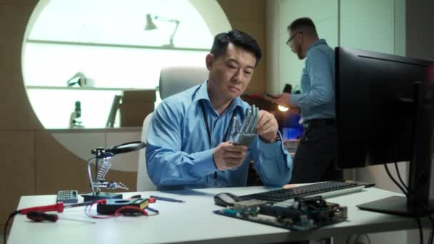 Розумний Азіатський Творець Сидить Перед Комп Ютером Тримає Роботів Руку — стокове відео