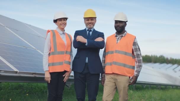 Three Workers Stand Look Camera Solar Panel Background Man Suit — Stock Video