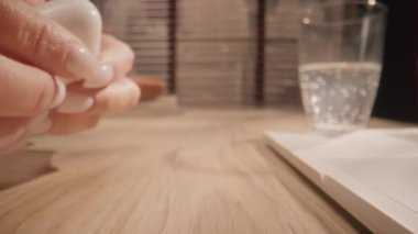 Yakın plan çekim. Kamera masa yüzeyindeki nesnelere doğru yavaşça hareket ediyor. İnsan kulaklığı açar, takar, müzik dinler ve geri koyar. Çevrimiçi serbest çalışma kavramı.