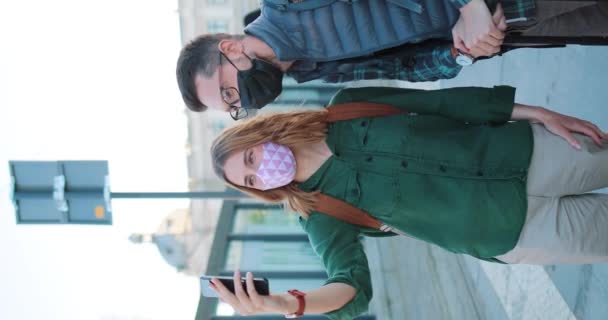 コロナウイルス感染に対してフェイスマスクを着用白人観光客の垂直撮影 署でビデオ通話してる 幸せな人々が電話カメラに親指を表示します Covid 19中の安全な旅 — ストック動画