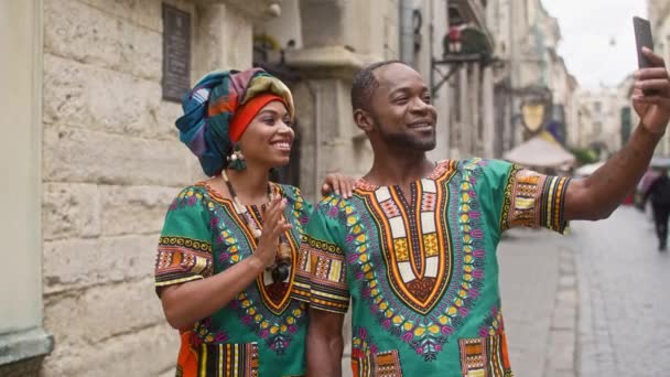 多文化男女穿着华丽的服装 穿着鲜艳传统服装的非洲夫妻们笑着摆姿势 男人和女人在涡轮机挥手在电话里 身着民族服装的印度人 — 图库视频影像