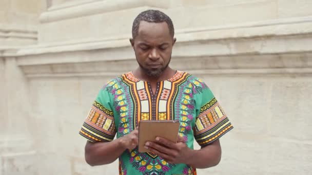 Afrikaanse Man Traditionele Kleding Staat Tegen Beige Muur Multi Etnische — Stockvideo
